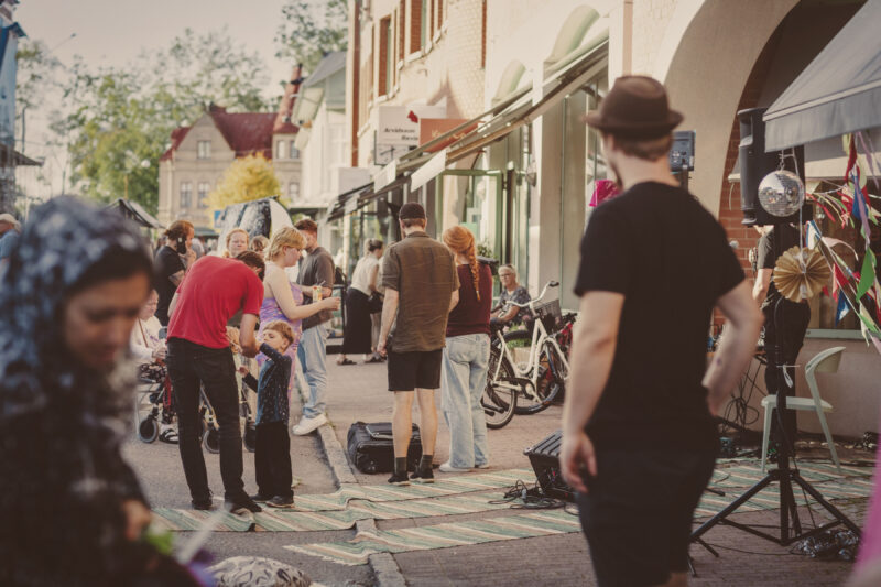 Människor står i småstadsmiljö